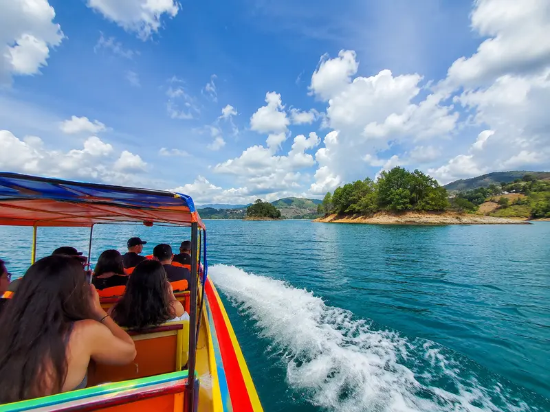 Colorful tourist boat cruising the turquoise Guatapé reservoir