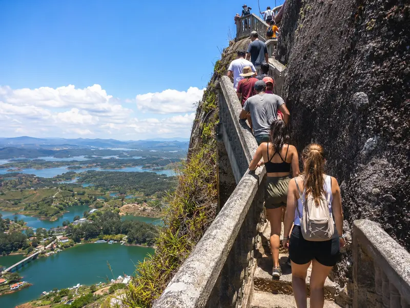 Travelers climbing the 740 steps of El Peñol Rock above the Guatapé reservoir