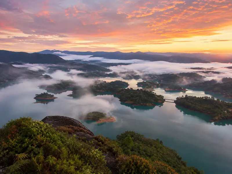 Sunrise over the mist-covered islands of the Guatapé reservoir